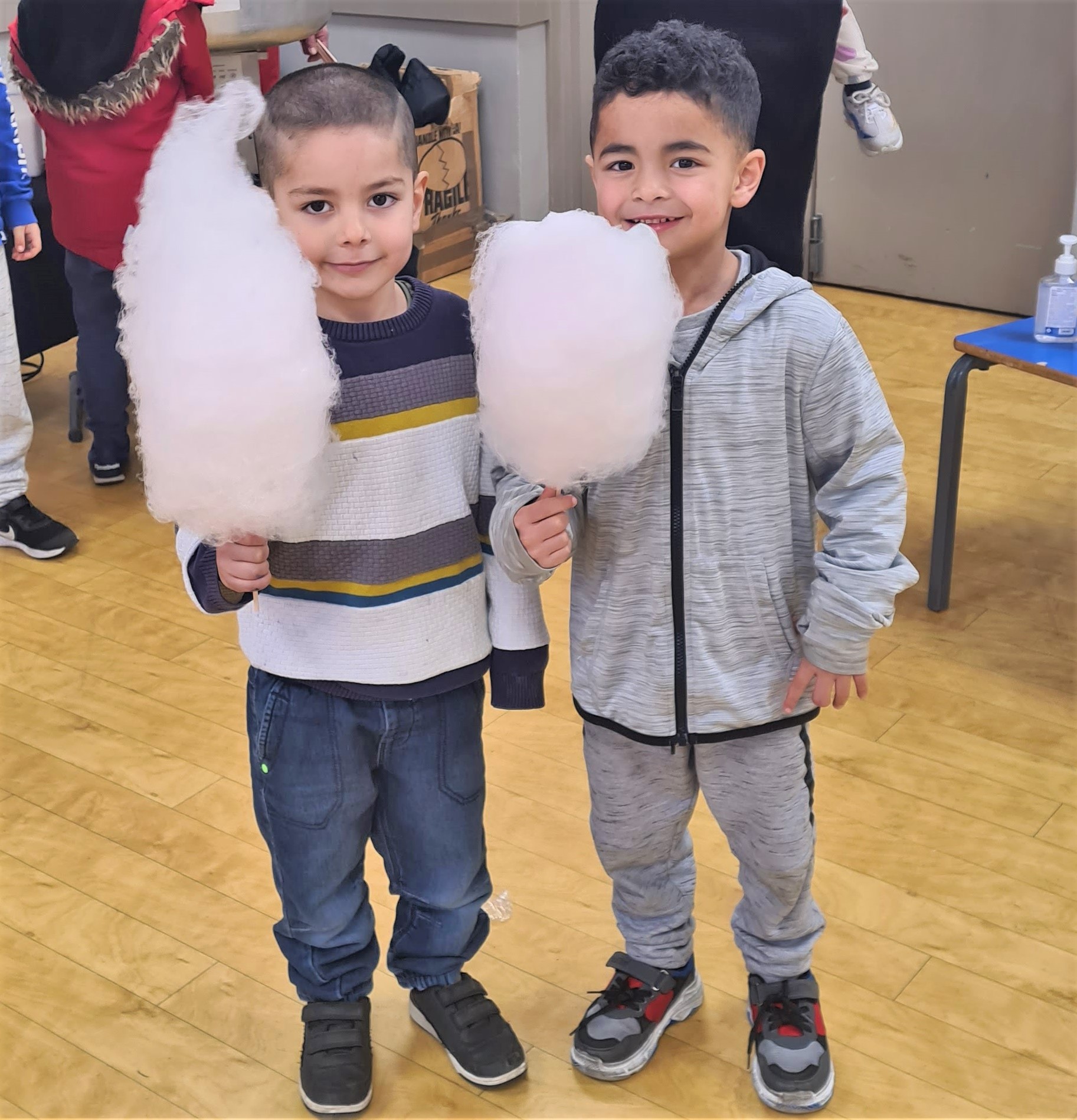Two small children holding very large candyfloss
