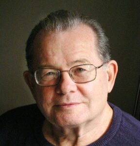Headshot of Anton Smith wearing glasses and a blue top
