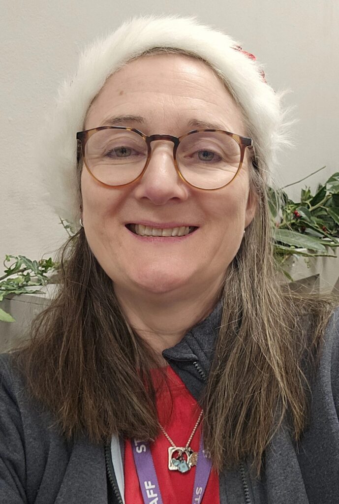 Woman with long hair and glasses wearing a Santa hat